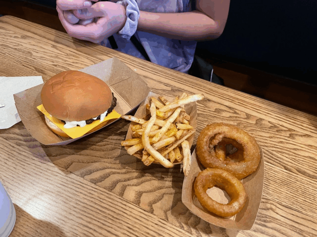 Audrey always chooses the kids cheeseburger with onion rings and fries. $8.49